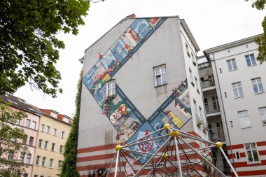 BERLİN, ALMANY - 6. Ağustos 2025: Orangotango, Pappsatt ve Şehrinizi Geri Alma 'nın farklı konumlarına sahip bir monopoly tahtasını gösteren bir duvarda 