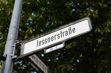 Jessnerstrasse caddesi tabelası Berlin, Almanya 'da. Kavşakta yol işareti var. Friedrichshain caddesinin yönünü gösteren konum rehberine yakın çekim.