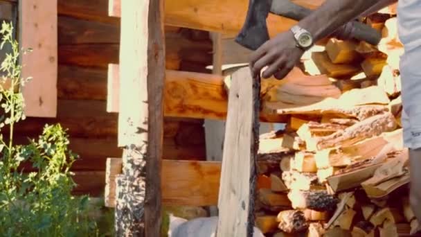 Man met ijzeren bijl hakken van hout — Stockvideo