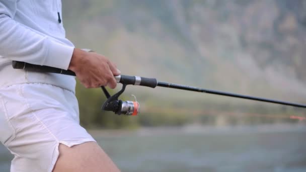 Hombre pescando en el río desde la roca — Vídeo de stock