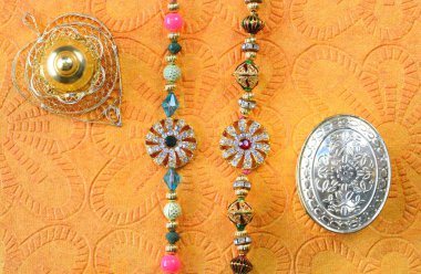 Hint festivali Raksha Bandhan 'ı kutluyoruz. Sarı zemin üzerinde taşlar olan renkli rakhi.