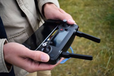 Bir adam insansız hava aracı için uzaktan kumanda tutuyor.