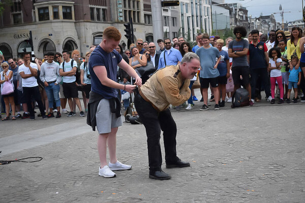 Street artist locked in chain in Amsterdam, Dam square