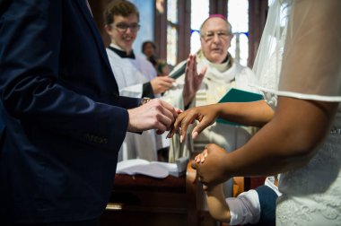 Beyaz tenli adam ve siyah tenli kadın kilisede evleniyorlar.