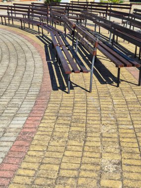 Asfaltlı bir meydanda sıralar