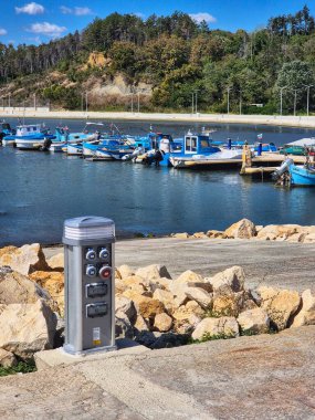 Şehrin eski limanı. Güneşli bir günde sakin bir liman. Limandaki balıkçı tekneleri. Elektrikli araçlar şarj istasyonu. Byala, Varna