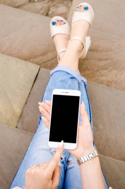 Yakın kadar beyaz Smartphone cep cep kadın şık yırtık kot uzun çivi Denim siyah Oled ekran taş arka plan ellerimi