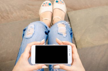 Yakın kadar beyaz Smartphone cep cep kadın şık yırtık kot uzun çivi Denim siyah Oled ekran taş arka plan ellerimi