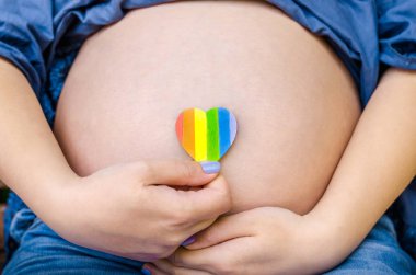 Hamile kadın kamera kalp Lgbt gurur hakları lezbiyen eşcinsel Biseksüel transseksüel Geek şehir güneşli gün arka plan üzerinde gösterir. Gurur mounth günü