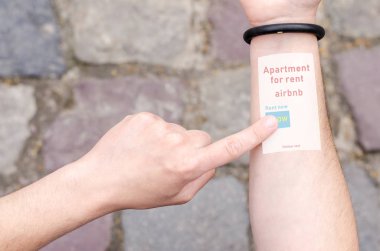 Lviv, Ukrayna - 03 Haziran 2018: Airbnb daire kira Online otel arama rezervasyon giyilebilir projeksiyon bilezik Smartphone cep telefonu için. Görünmez teknoloji yenilikler gelecek kavramı