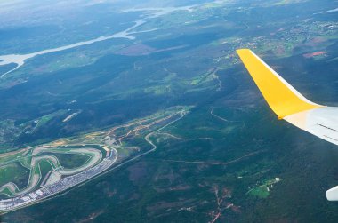 Uçak pencere Dünya'dan görünüm nehir ve bulutlar seyahat turizm İstanbul Türkiye zemin. Bulutların üzerinde zemin üzerinde bulutlu fırtınalı gökyüzü uçan bir uçağın kanat.