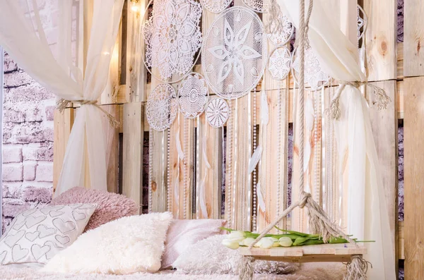 Yatak odası çatı tasarımı yatak yumuşak yastık gölgelik ile salıncak Beyaz Laleler Rüya yakalayıcı tüyler ve bir ahşap arka plan asılı inci ile