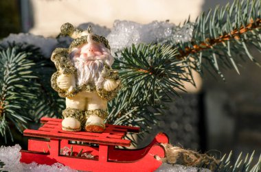 Karda kırmızı kızak üzerinde bir Noel ağacı kavramı ile kış yeni yıl Noel Baba oyuncak figür