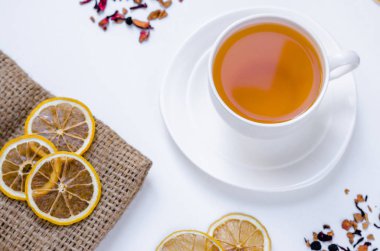 Turuncu bitkisel tarçın ve kakule tatlım beyaz fincan beyaz ahşap bir masa üzerinde Noel çay aromalı 