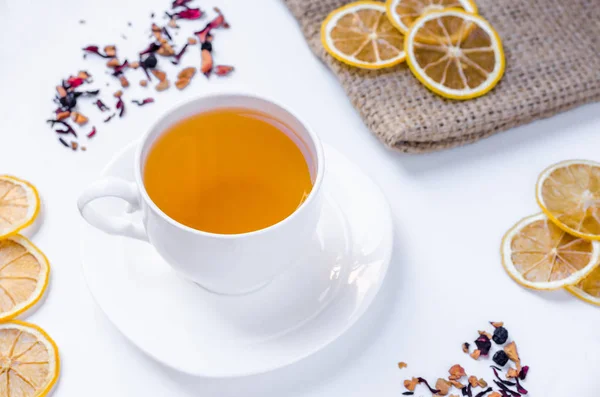 Orange herbal flavored christmas tea with cinnamon and cardamom honey white cup on a white wooden table