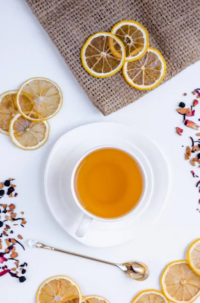 Orange herbal flavored christmas tea with cinnamon and cardamom honey white cup on a white wooden table