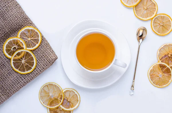 Turuncu bitkisel tarçın ve kakule tatlım beyaz fincan beyaz ahşap bir masa üzerinde Noel çay aromalı 