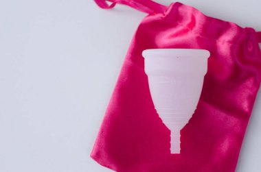 Pembe arka plan sağlık qynecology kavramı beyaz adet fincan sıhhi peçete tampon tutan kadın el yakın 