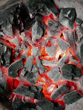 Kömür kabında turuncu alevi olan aşırı sıcak, yanan siyah kömür parçalarını kapatın. Afrika 'da eski günlerde ya da zamanda yerel ya da geleneksel yemek pişirme, ızgara yapma metodu için yangın kurulumu.