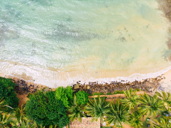 Playa de arena aérea, vista superior de una hermosa playa de arena aérea con las olas azules rodando en la orilla, algunas rocas presentes — Foto de Stock
