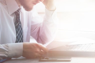 Buruşuk kağıt ile arkasında oturan genç işadamı