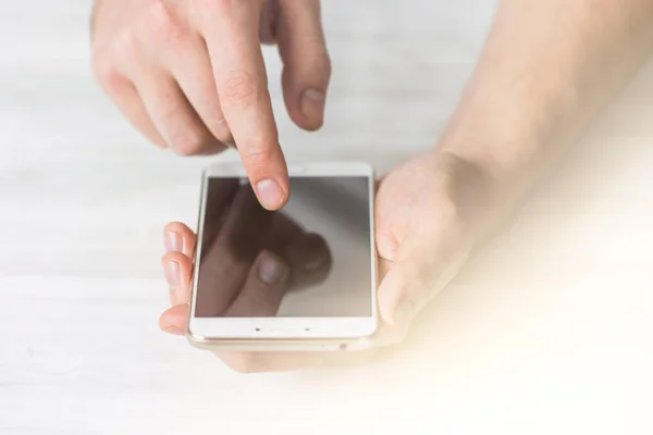 Hombre usando smartphone una pantalla táctil manos de teléfono inteligente cerrar tonificación de la luz — Foto de Stock