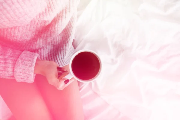 Chica en la cama con suéter de lana sosteniendo taza de café copia espacio vista superior tonificación de la luz —  Fotos de Stock