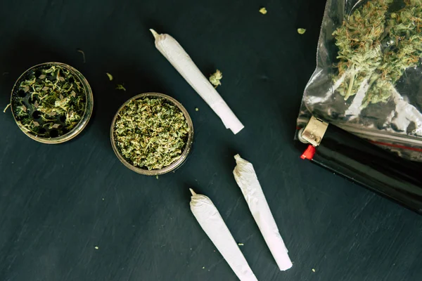 Marihuana con tricomas y hierba triturada en una mesa negra Macro de marihuana — Foto de Stock