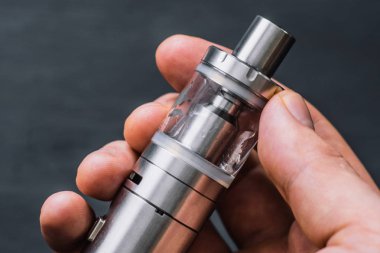 arka plan duman. Elektronik sigara veya vape cihaz ile tutarak Vape adam