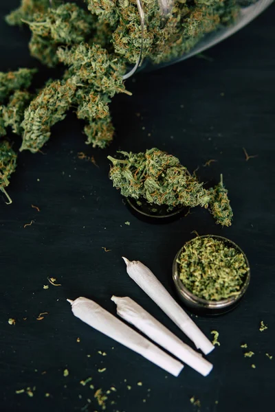 Makro von Cannabisknospen zerkleinert Unkraut auf einem schwarzen Tisch insta close up Marihuana mit Trichomen und UnkrautJoint — Stockfoto