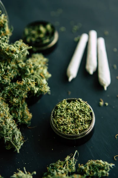 Marihuana con tricomas y hierba aplastada en una mesa negra urge cerrar Macro de brotes de cannabis — Foto de Stock