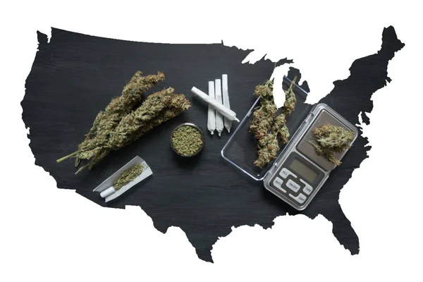 Marijuana, skalor, sidostycken och cannabis grinder ogräs på en svart trä bordsskiva ovanifrån — Stockfoto