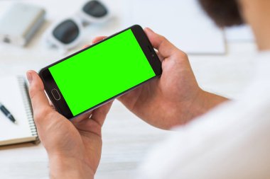 Online ödeme plastik kart adam kullanan bir akıllı telefon ile yatay bir yeşil ekran kullanımı ile