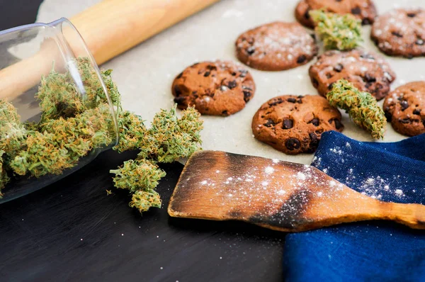 Conceito de cozinhar com erva de cannabis, biscoitos com cannabis e botões de maconha na mesa. Concep — Fotografia de Stock