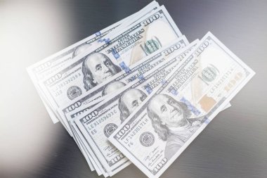 Bize yeni bir siyah Ahşap dokulu masaya yüz dolarlık banknotlar. Işık tonlama