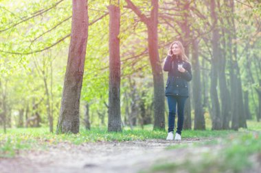 Evet, bir sabah bir akıllı telefon ile bir parkta yürüyüş ve kahve, hafif tonlama kızdır