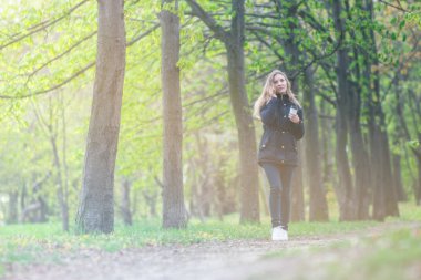 Evet, bir sabah bir akıllı telefon ile bir parkta yürüyüş ve kahve, hafif tonlama kızdır