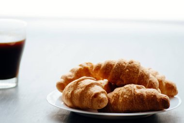 Kahve fincanı ve taze pişmiş kruvasanlar ahşap arka plan üzerinde. En iyi görünümü ışık tonlama.,