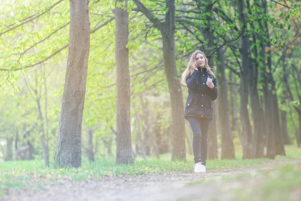 Evet, bir sabah bir akıllı telefon ile bir parkta yürüyüş ve kahve, hafif tonlama kızdır