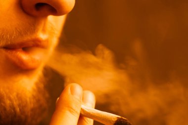 Bir adam ot esrar sigara esrar ve çakmak onun ellerinde. Işık tonlama