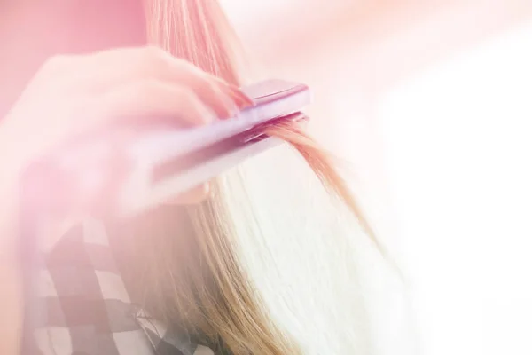 Mujer haciendo peinado con alisador de cabello, tonificación ligera — Foto de Stock