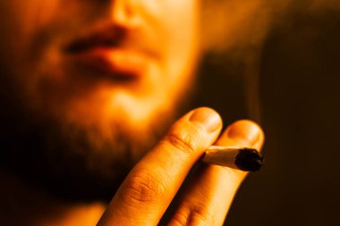 esrar ot, onun ellerini A adam ortak bir çekiyor. Bir sarı tonlama duman