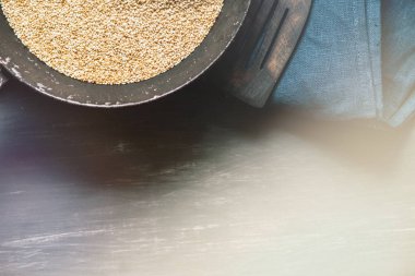 Tohum tohum vintage bir tavada rustik tarzı bir koyu renkli doğal dokulu ahşap, ışık tonlama bir arka plan karşı doğal bir tahta kaşık, bir kaşık