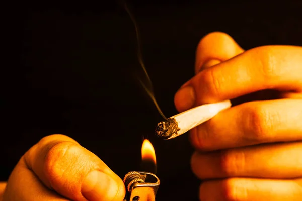 Kannabisz füvet, egy közös, az ő kezét A férfi dohányzik. Füst egy sárga alakformálás — Stock Fotó