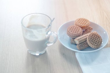 Fincan kahve ve bisküvi çul ve ahşap masa, ışık tonlama