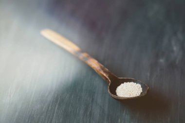 Tohum tohum içinde doğal bir tahta kaşık arka planı koyu renk doğal dokulu ağacı rustik tarzda bir kaşık. Tonlama imzalamak için bir tel ile ışık