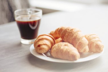 Kahve fincanı ve taze pişmiş kruvasanlar ahşap arka plan üzerinde. Işık tonlama üstten görünüm