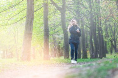 Evet, bir sabah bir akıllı telefon ile bir parkta yürüyüş ve kahve, hafif tonlama kızdır