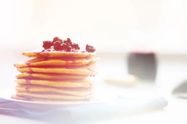 Delicious golden pancakes with fresh blackberries and blackberry jam , light toning