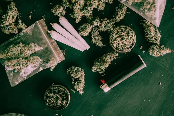 Brotes de cannabis sobre la mesa en el paquete y articulación sobre la mesa — Foto de Stock